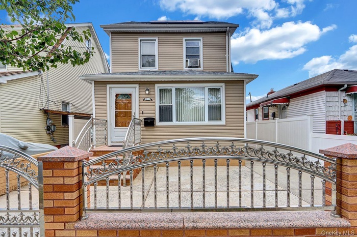 American foursquare style home featuring a fenced front yard and a gate