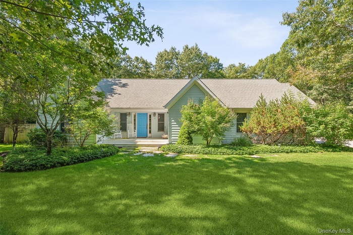 Ranch-style home featuring a front yard and roof with shingles