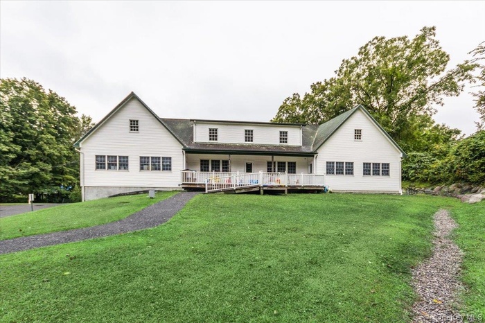 Rear view of property featuring a lawn and covered porch