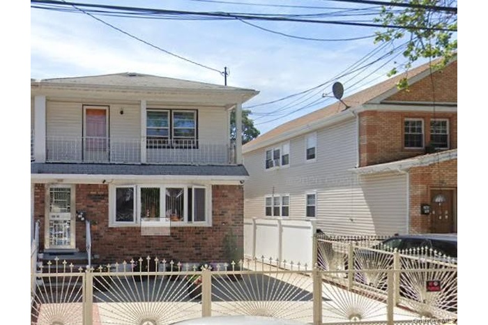 View of front facade with brick siding and a balcony