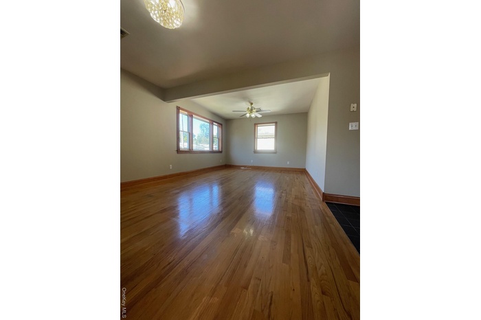 Unfurnished room with dark wood-style floors and ceiling fan
