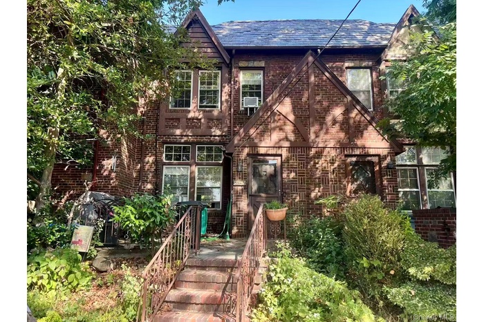 View of front of home featuring brick siding and stairway