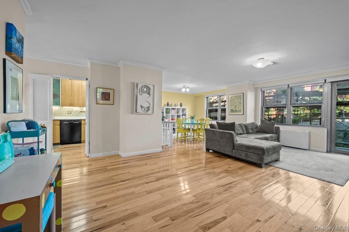 Living area featuring ornamental molding and light wood finished floors