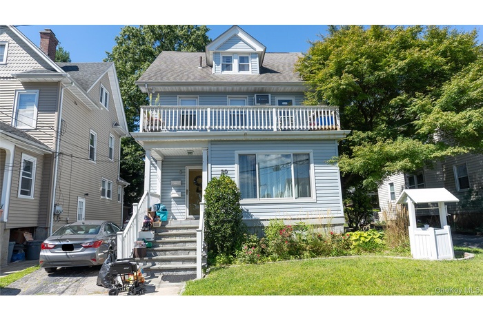 American foursquare style home with a shingled roof and a front yard
