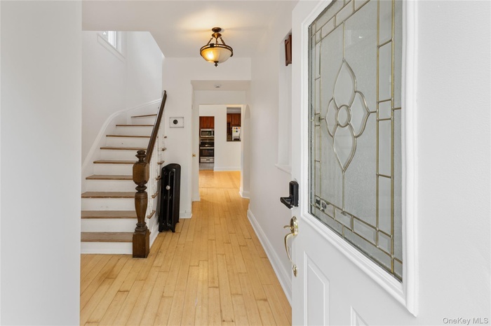 Foyer featuring light wood finished floors and stairs