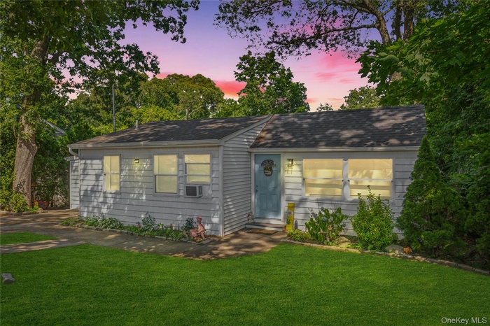 View of front of house featuring a lawn and a shingled roof