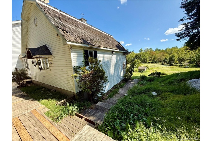 View of side of property with a chimney and a gambrel roof