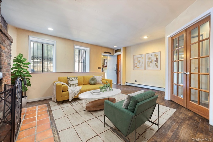 Living room featuring a baseboard heating unit, recessed lighting, and french doors