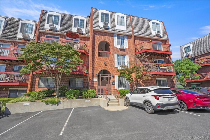 View of property featuring uncovered parking.