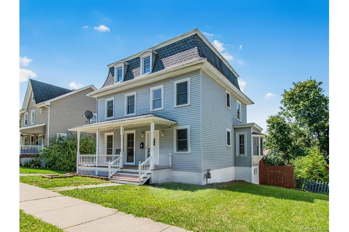 Victorian home featuring mansard roof and covered porch
