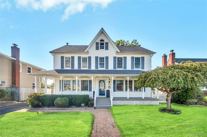 View of front facade featuring covered porch and roof with shingles