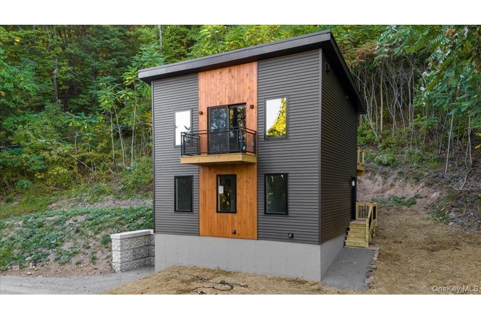 Modern home with a balcony and a wooded view