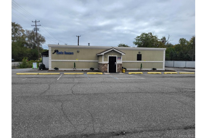 View of commercial property with uncovered parking