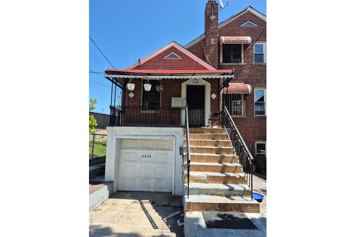 Multi unit property featuring brick siding, fence, a chimney, and a garage