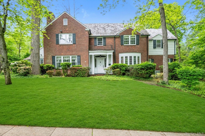 View of front of property with brick siding and a front yard