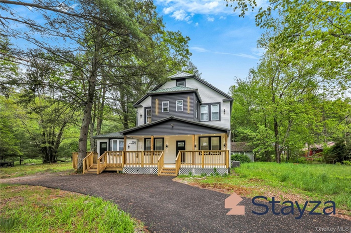 View of front of property with a standing seam roof, a metal roof, and a porch