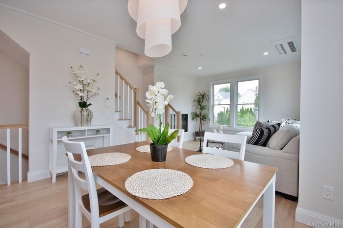 Dining room featuring stairway, light wood finished floors, and recessed lighting