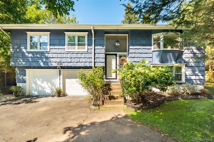 Bi-level home with driveway and an attached garage