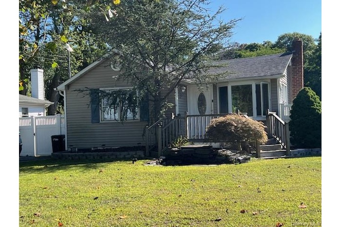 Bungalow with a front yard, a chimney, and a gate