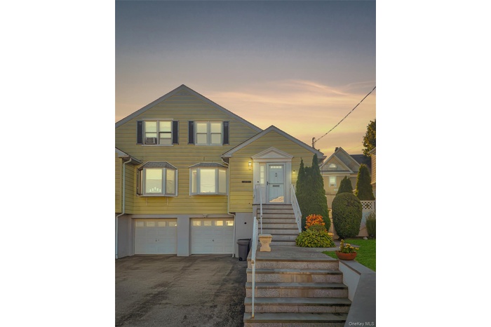 View of front facade featuring an attached garage and driveway