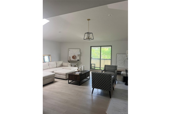 Living area featuring light wood-type flooring, a chandelier, and recessed lighting