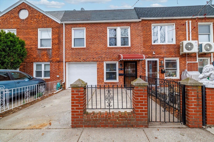 View of property with a fenced front yard, concrete driveway, an attached garage with brick siding.