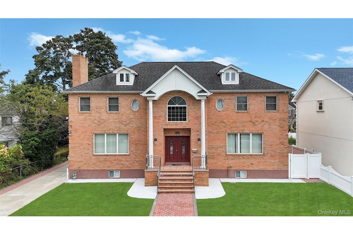View of front facade featuring brick siding and a chimney