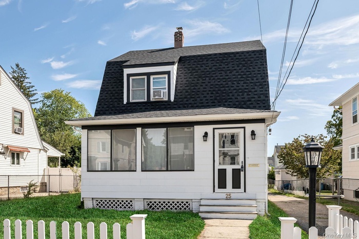 Dutch colonial featuring a shingled roof, a sunroom, a chimney, and a gambrel roof