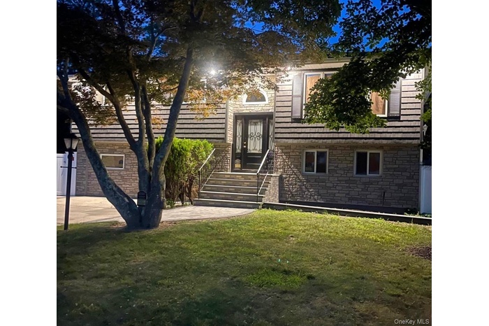 View of front facade featuring stone siding and a front yard