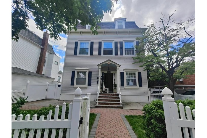 Victorian home with a gate, a fenced front yard, and mansard roof