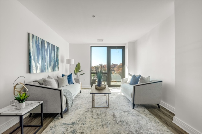 Living room featuring wood finished floors, visible vents, and baseboards