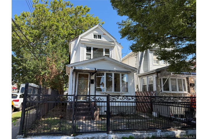 View of front of property with a fenced front yard, a gate, and a gambrel roof