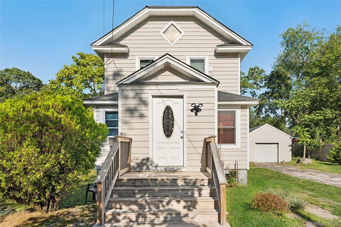 View of front of house with an outdoor structure and a shingled roof