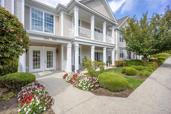 Neoclassical / greek revival house with french doors, a balcony, and covered porch