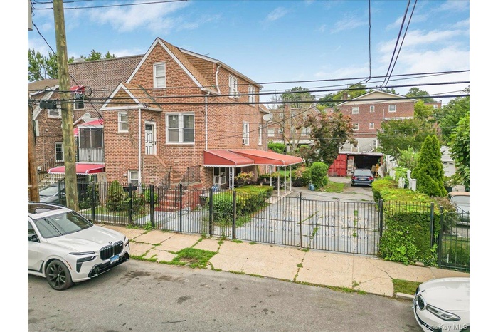View of front facade with brick siding and a fenced front yard