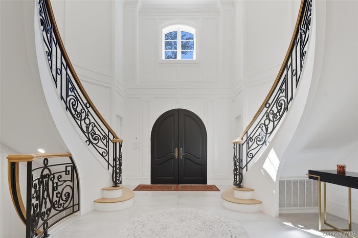 Entryway with stairs and a towering ceiling