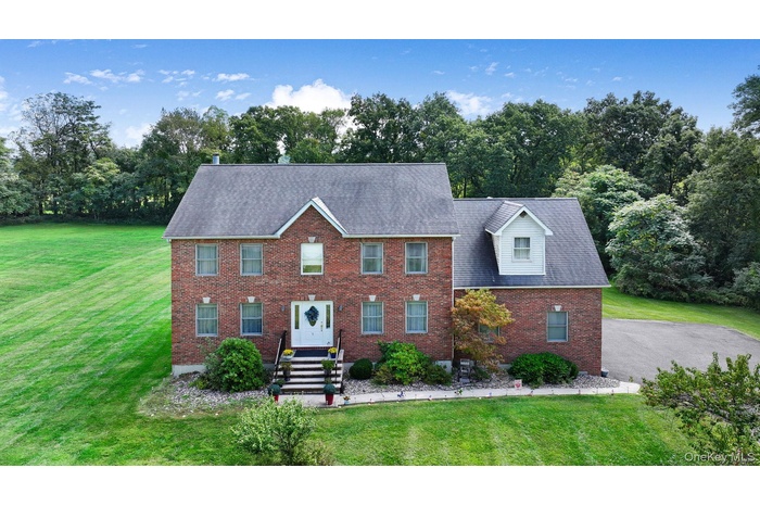 Colonial-style house with a front lawn and brick siding