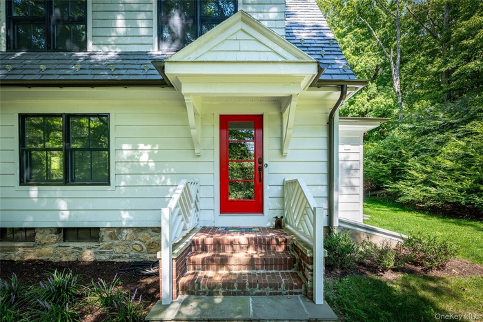 View of exterior entry featuring a shingled roof