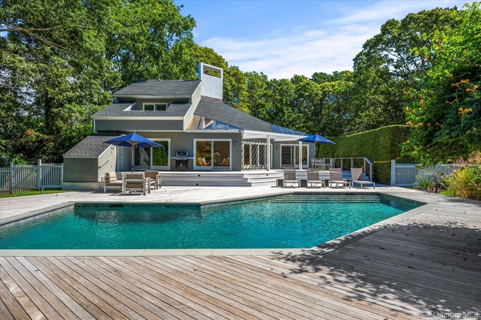 View of pool, a wood deck and home