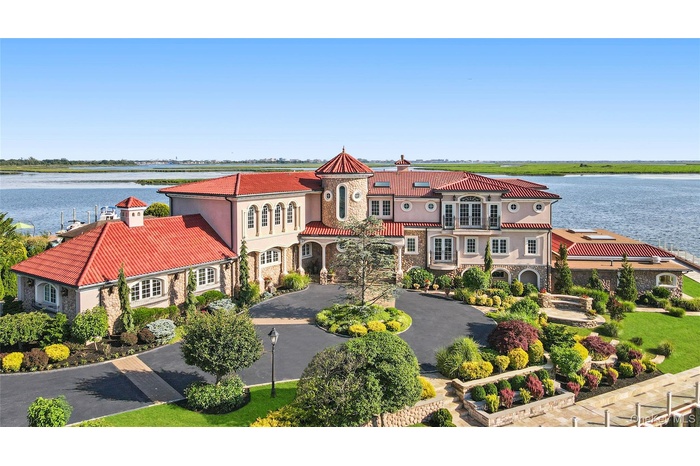Mediterranean / spanish house with a water view, curved driveway, stone siding, and stucco siding