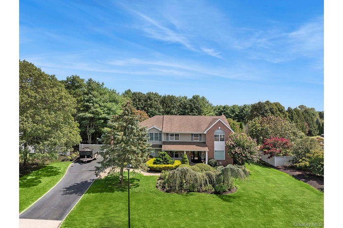 Aerial view of property and surrounding area featuring a tree filled landscape