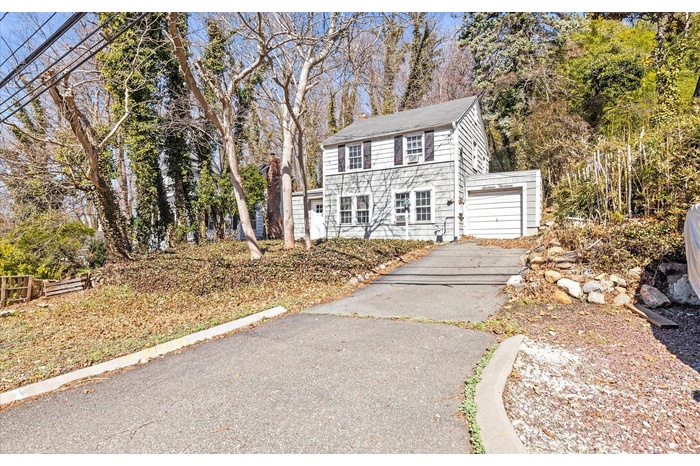 View of front of home with driveway and a garage