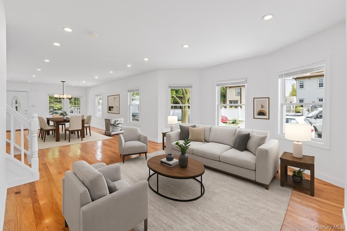 Living room with recessed lighting, light wood-style flooring, and stairway