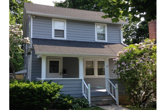 View of front of home with a porch and roof with shingles