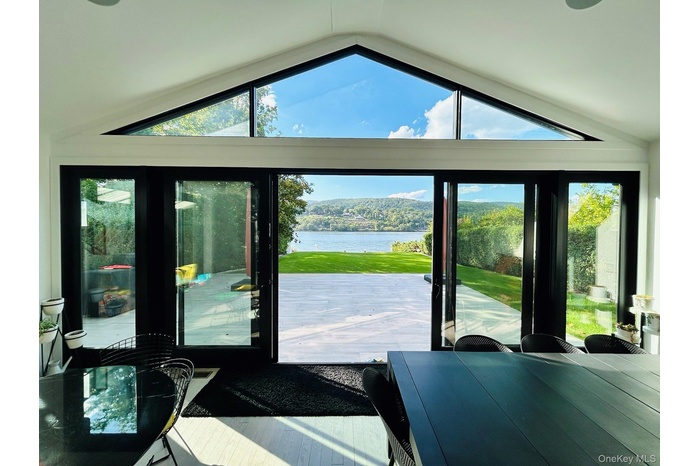 Doorway to outside featuring a water view, lofted ceiling, and plenty of natural light