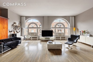 This chic and stylish, sunny Chelsea loft has 12 foot ceilings with two rare, expansive floor to ceiling arched windows, classic details like a cast iron column and exposed brick, ...