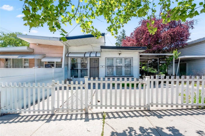View of front facade with a fenced front yard and a gate