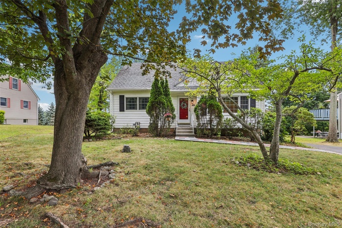View of front of home featuring a front yard, roof with shingles, and entry steps