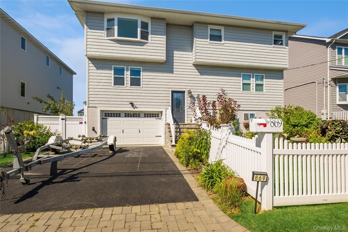 View of front of house with asphalt driveway and an attached garage