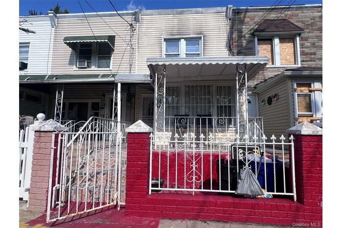 View of front facade featuring a porch, a fenced front yard, and a gate